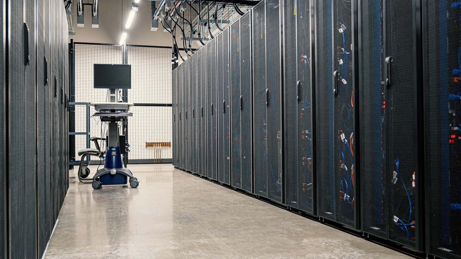 An aisle between rows of server cabinets in a data center