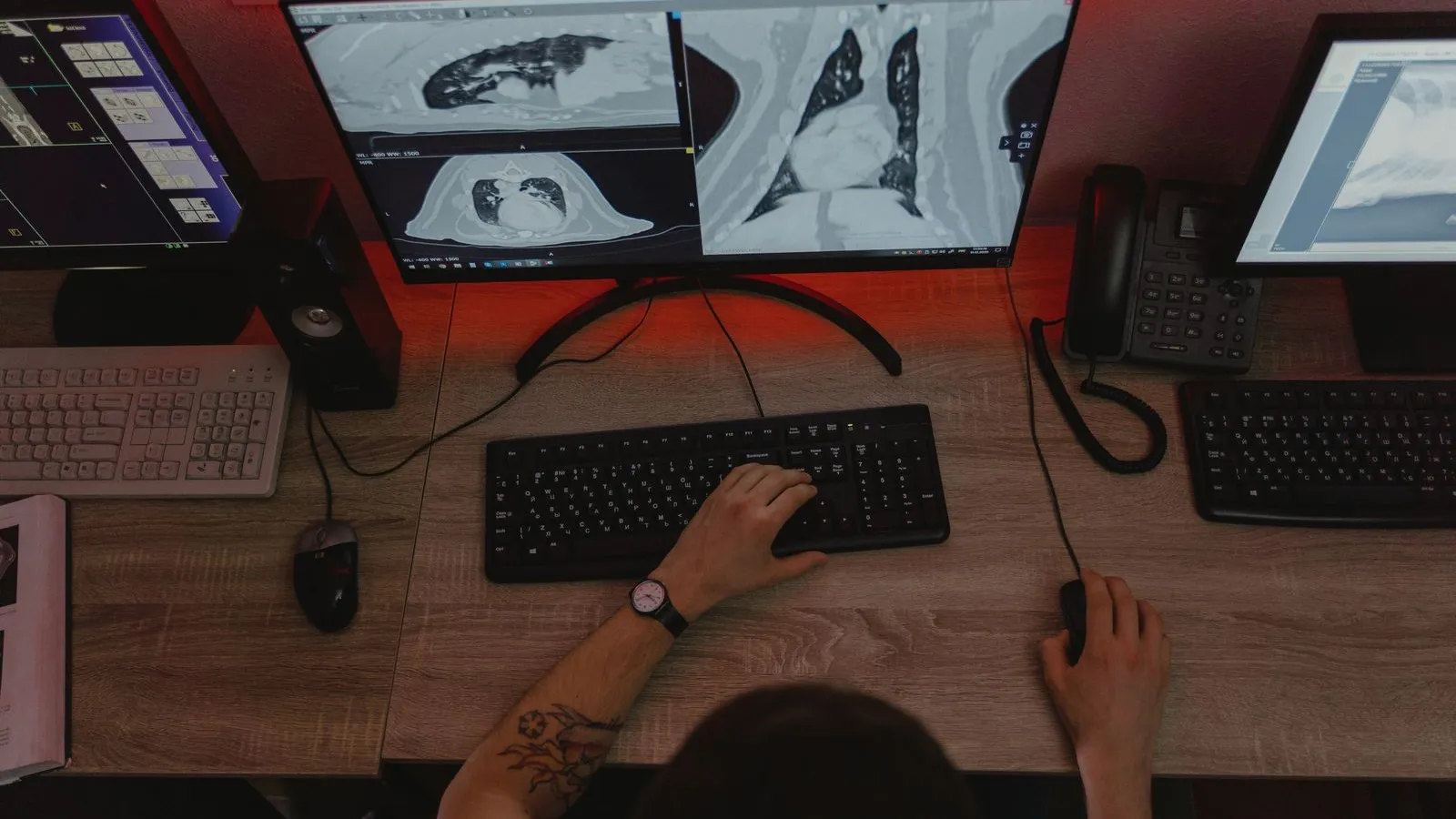 A clinician reviews CT scan images on several monitors