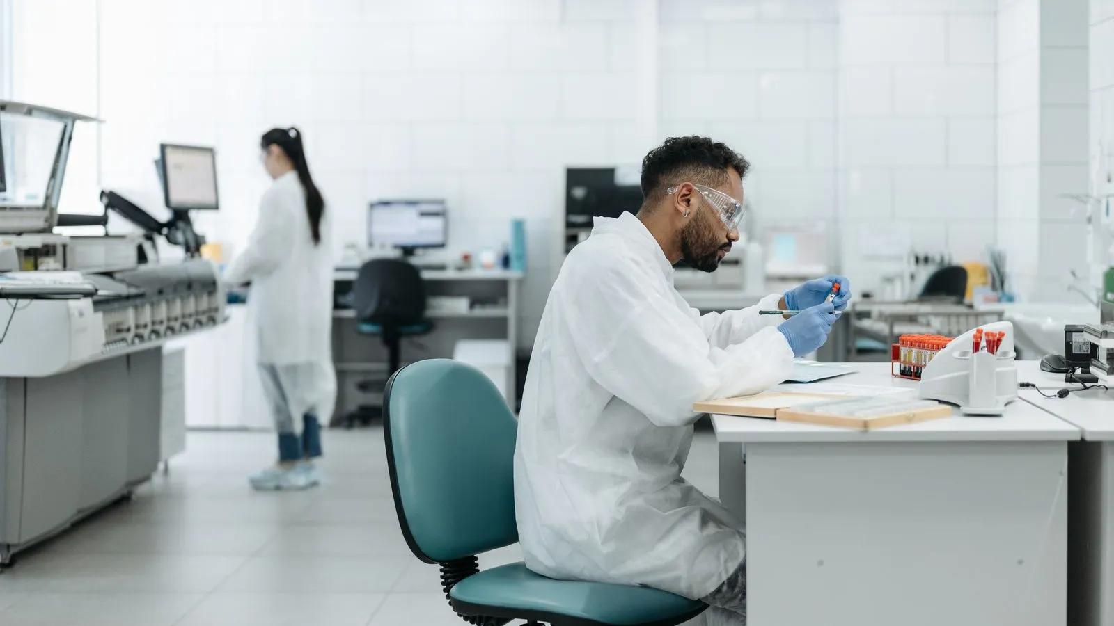 Scientists work at benches in a modern pharmaceutical research laboratory
