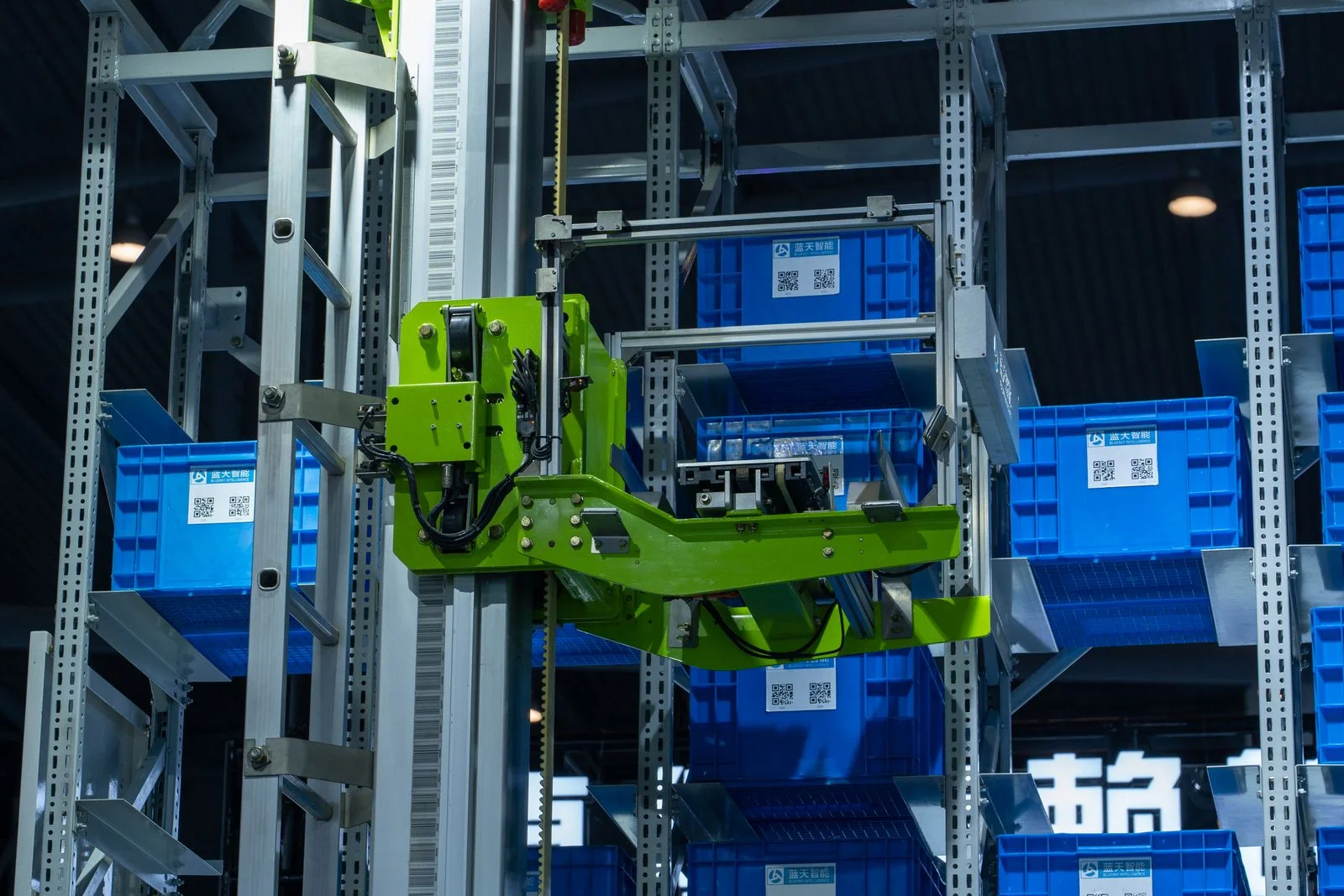 An automated storage and retrieval system in a warehouse: a robotic lift moves plastic totes between tall racks
