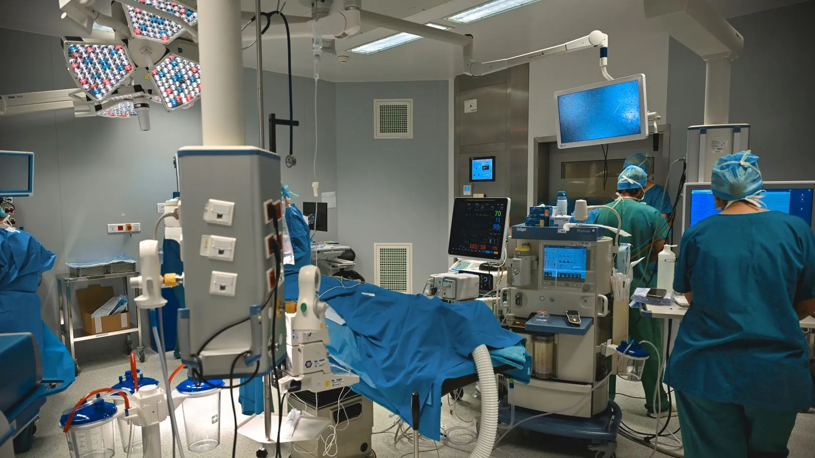 Surgical team at work in a modern operating room with monitors and equipment