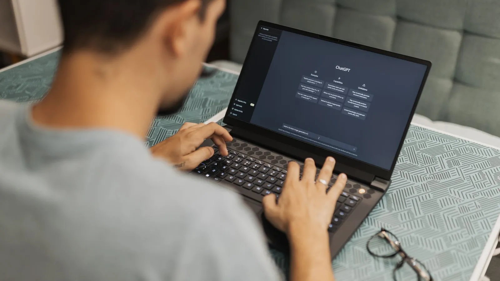 Person typing a prompt into an AI chat assistant on a laptop
